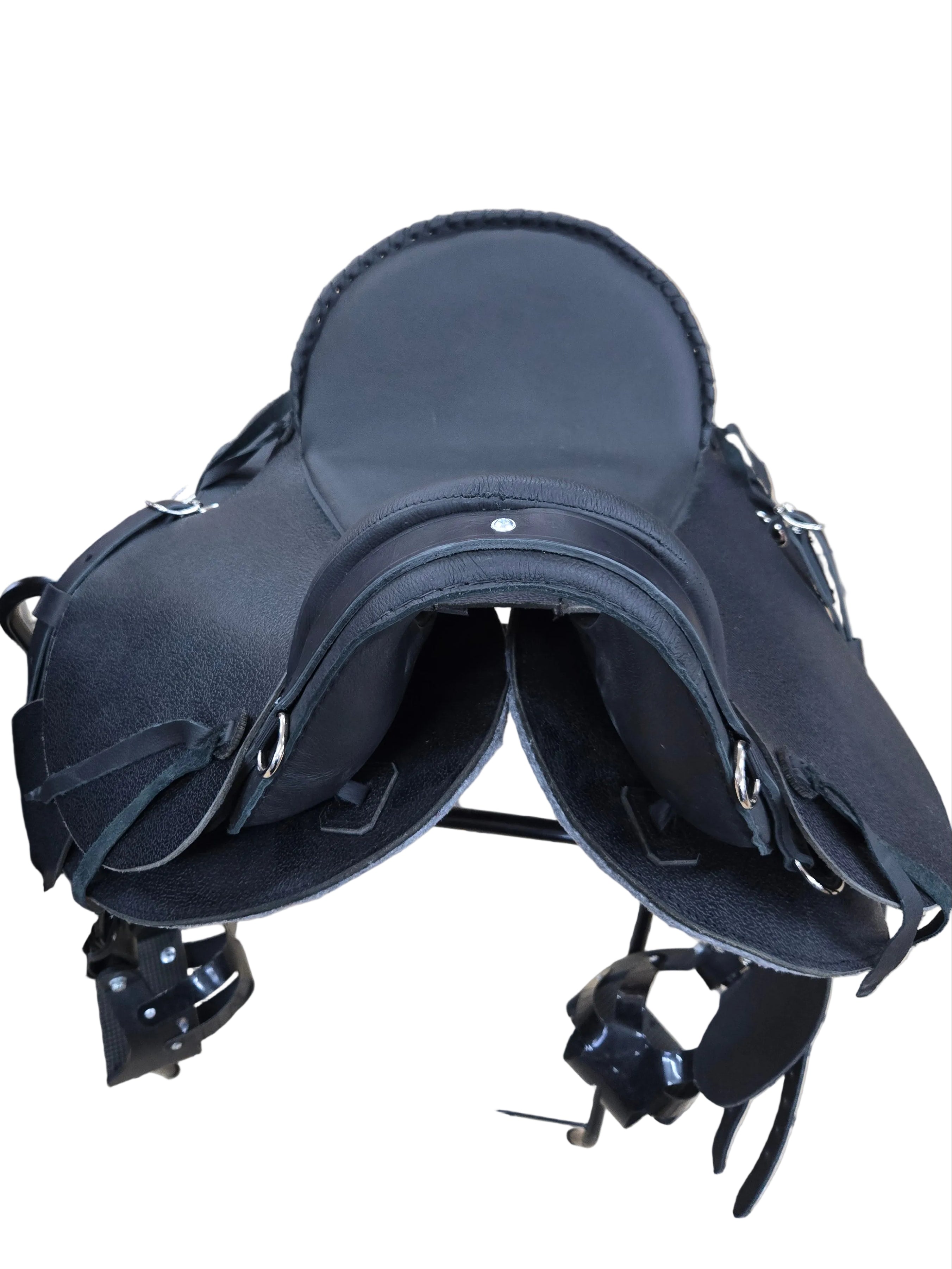 Black leather saddle on a tiled floor with people in the background